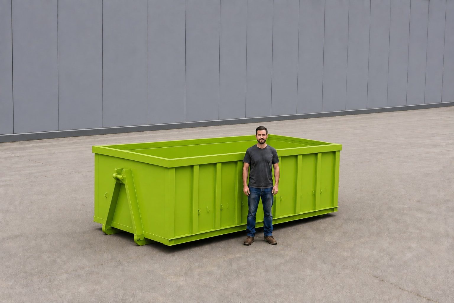 Lime green 15-yard roll-off container photographed side-on against a plain wall, with a person standing beside it to show the height of the sides
