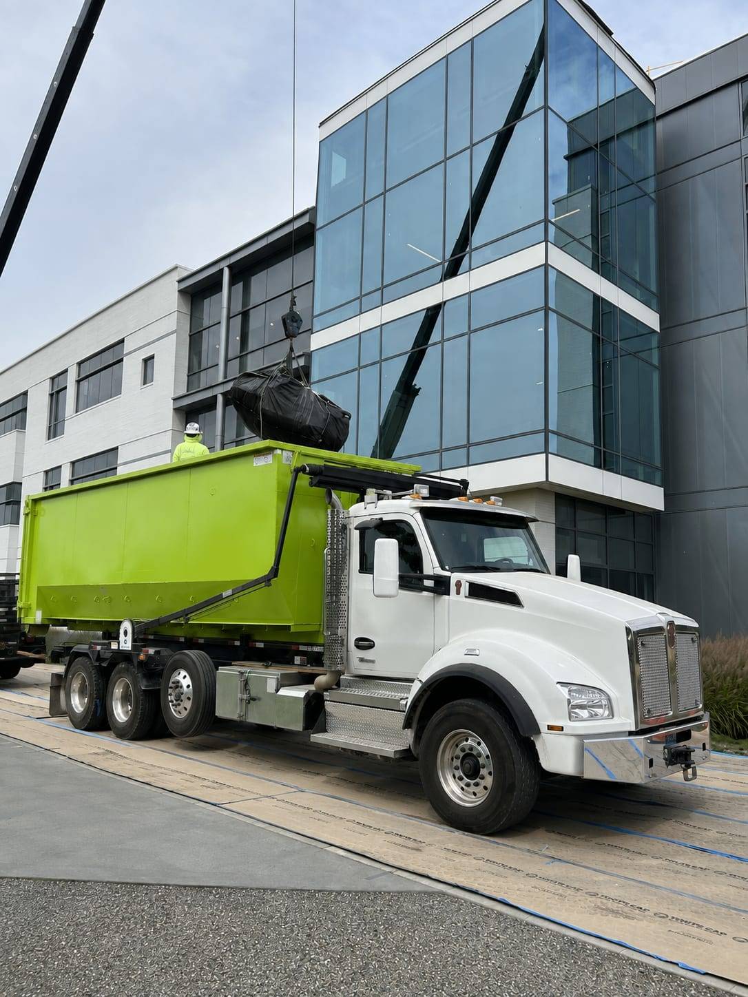 Roll-off container loaded by crane at a Seattle commercial construction site