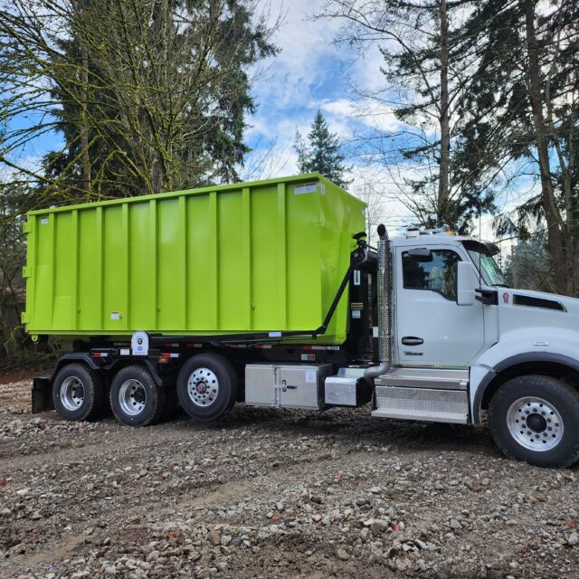 A large 30-yard roll-off dumpster sitting on a gravel construction site, ideal for major demolition and home renovation debris.